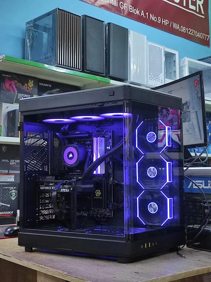 Rakitan PC gaming modern dengan casing kaca panorama, pendingin AIO, dan lighting biru di toko komputer